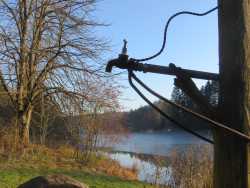 Am Ufer des Sees gibt es einen Wasserhahn und ein Becken. Es öffnet sich ein etwas anderer Blick auf den See (im Vordergrund der Wasserhahn).