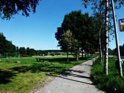 Blick auf den Spielplatz am Ortausagang von Großtissen. Der Weg ist von Birken umrahmt.