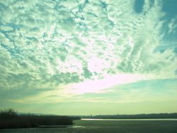 Sonenuntergang über dem Federsee. Die Sonne scheint durch die Wolken. Es dauert nicht mehr lange, bis sie für heute untergeht. Ein Tag am Federsee geht zu Ende.