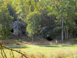 Der Hohlenstein mit dem Hohlenstein-Stadel der kleinen Scheuer und der Bärenhöhle in einem mächtigen Jurafelsen (Blick vom Wander-/Radweg auf der gegenüberliegenden Seite der Lone)